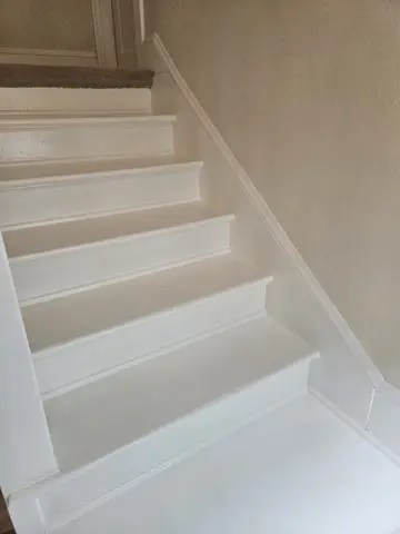 White painted wooden staircase with evenly spaced treads and risers, viewed from above, showing clean finish and white